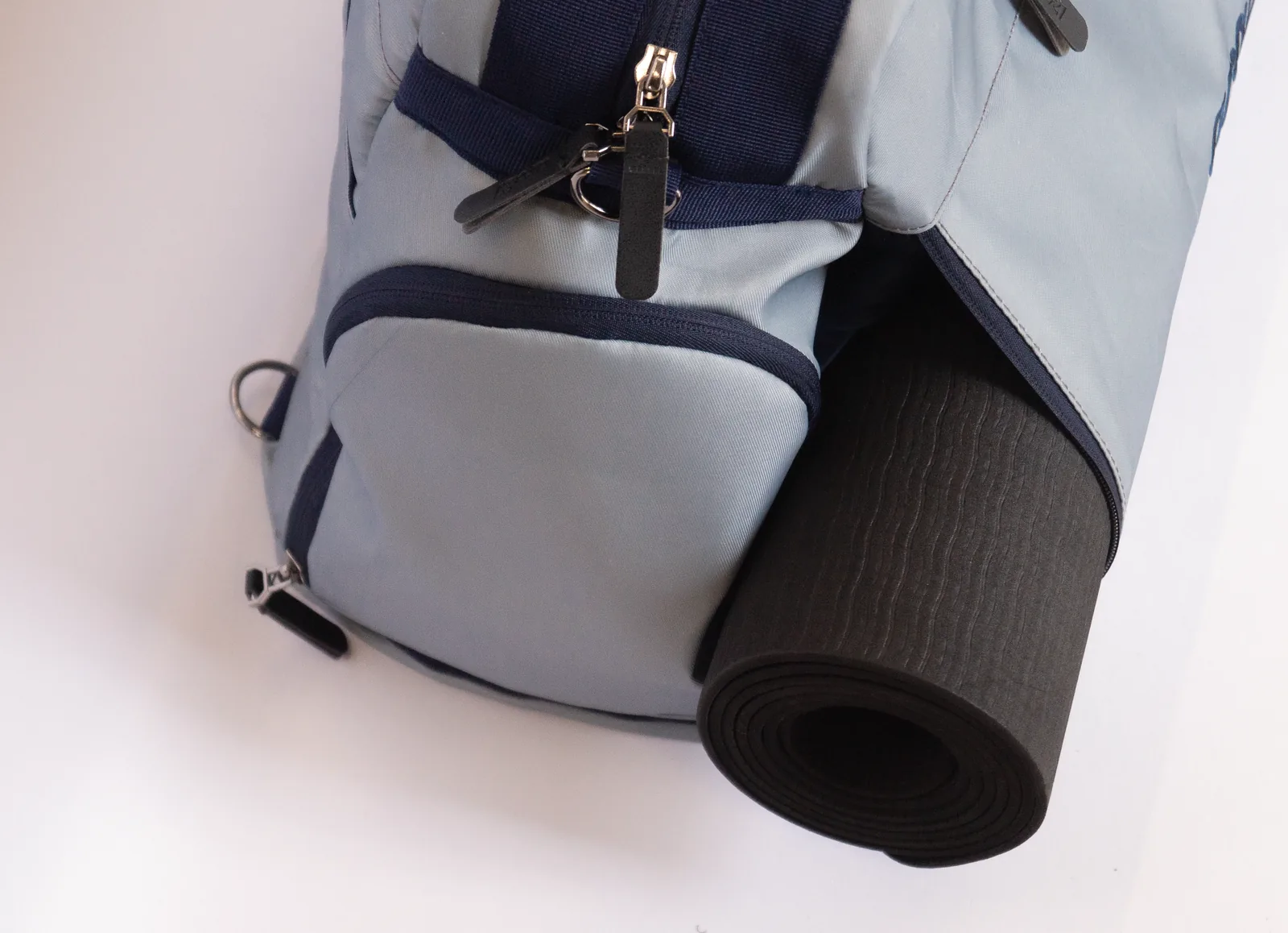 Slate Duffel from the side, yoga mat rolled along the base